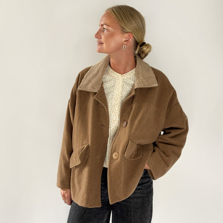 Woman modeling a Car Coat sewing pattern in brown, featuring a corduroy collar and relaxed fit for comfortable layering.
