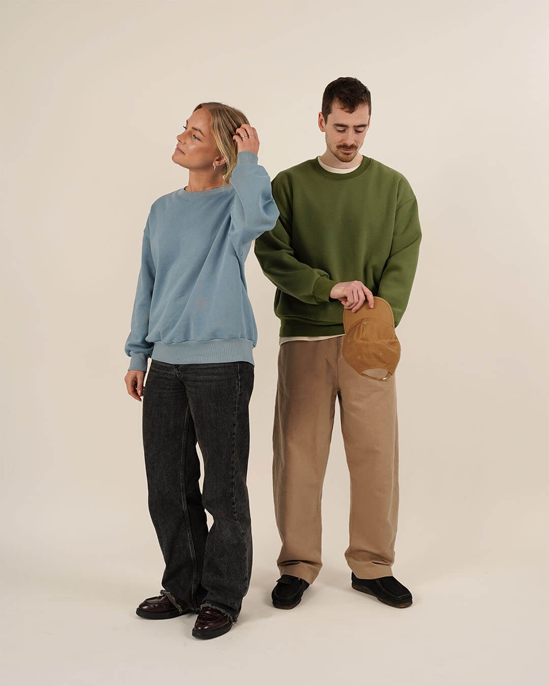 Two models showcasing unisex sewing patterns with casual outfits, featuring an oversized sweatshirt and relaxed trousers.