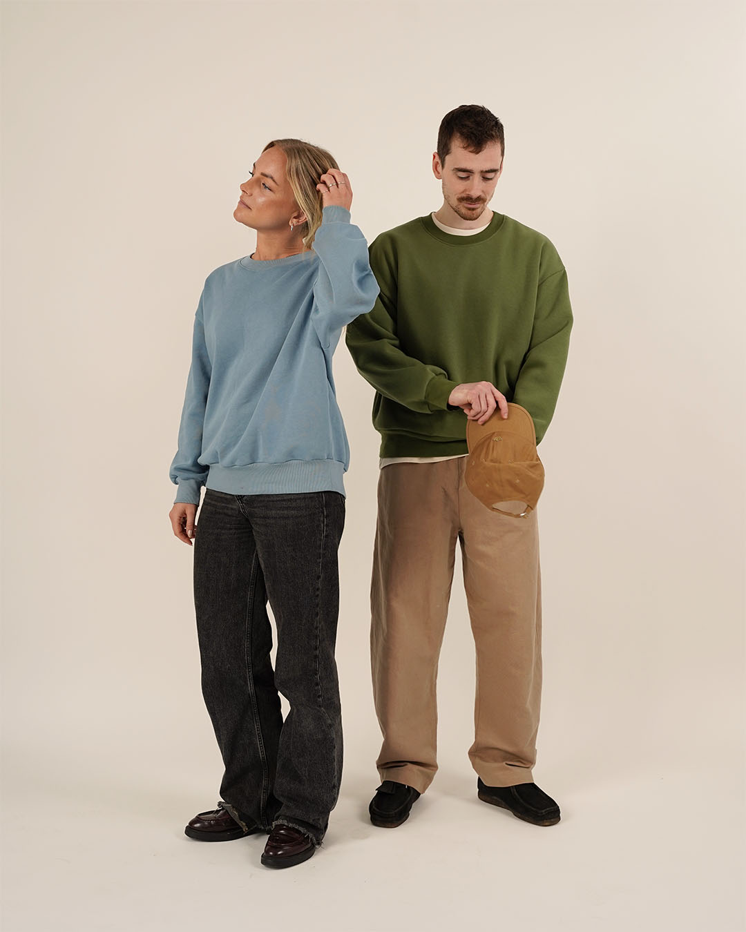 Two models showcasing unisex sewing patterns with casual outfits, featuring an oversized sweatshirt and relaxed trousers.