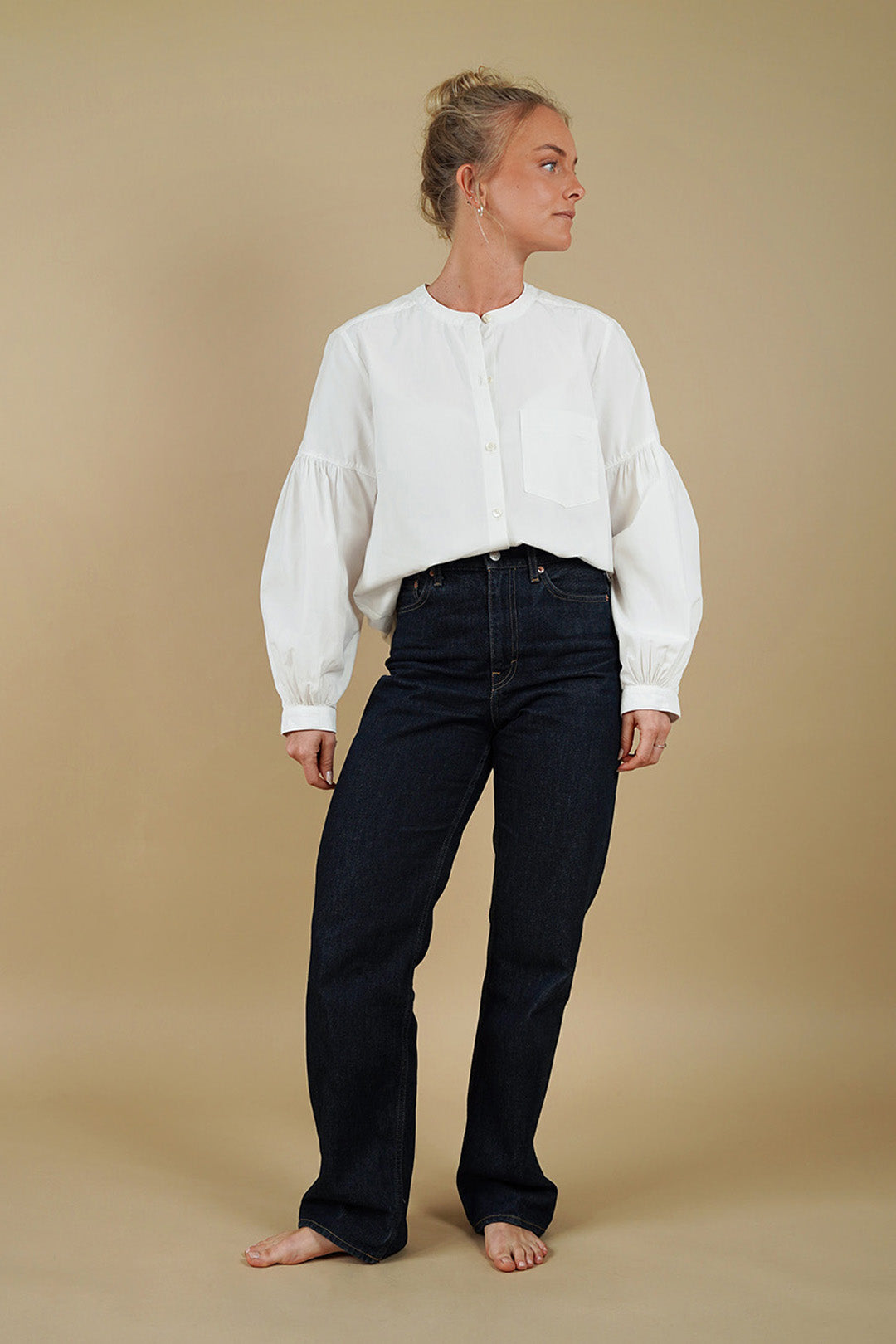 A woman models a stylish outfit featuring The Perfect Shirt and dark denim jeans against a neutral background.