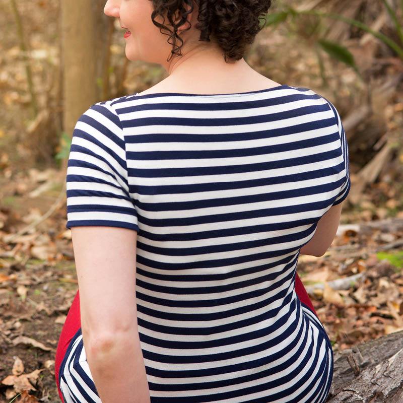 Back view of a woman wearing a stylish Boatneck style T-shirts with stripes in a natural setting.