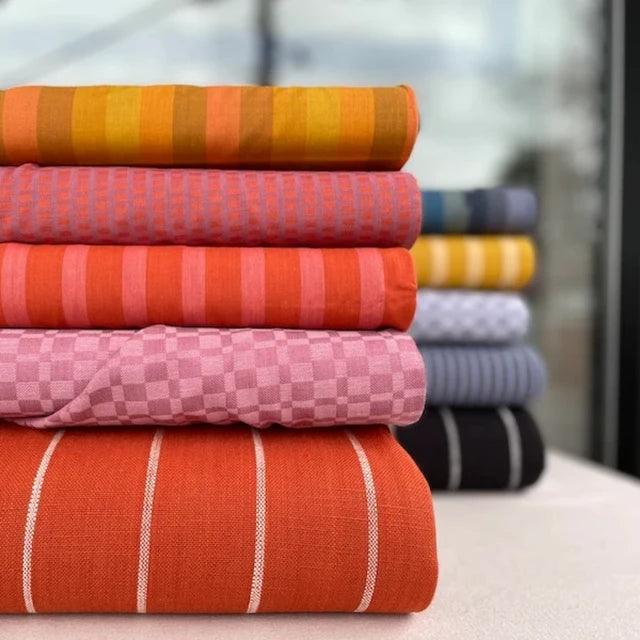 Top Fabric Webshops for Sewing Projects - Colorful and varied fabric stacks for DIY crafts.