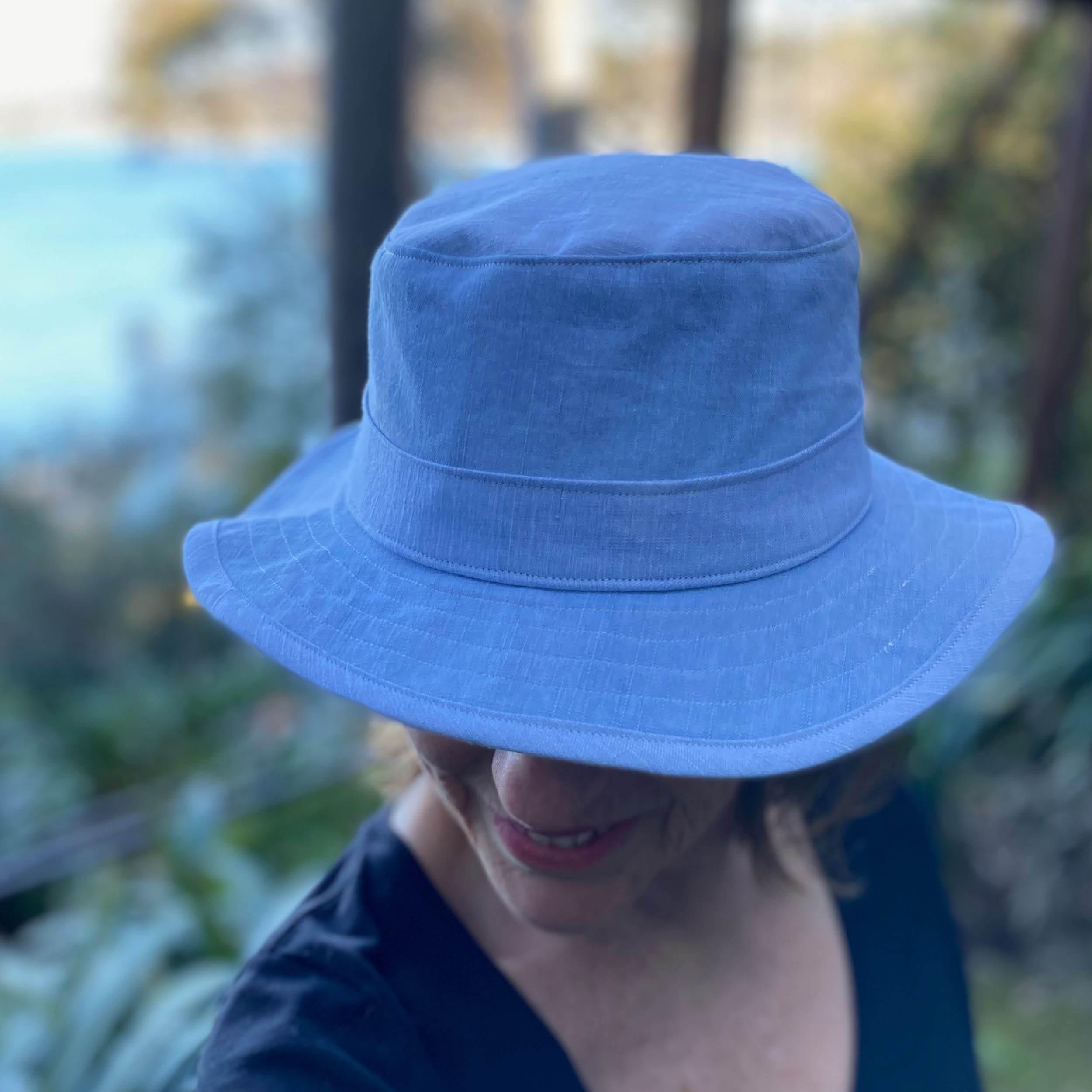Bucket hat tutorial - a close-up of a person wearing a light blue bucket hat, showcasing sewing skills.