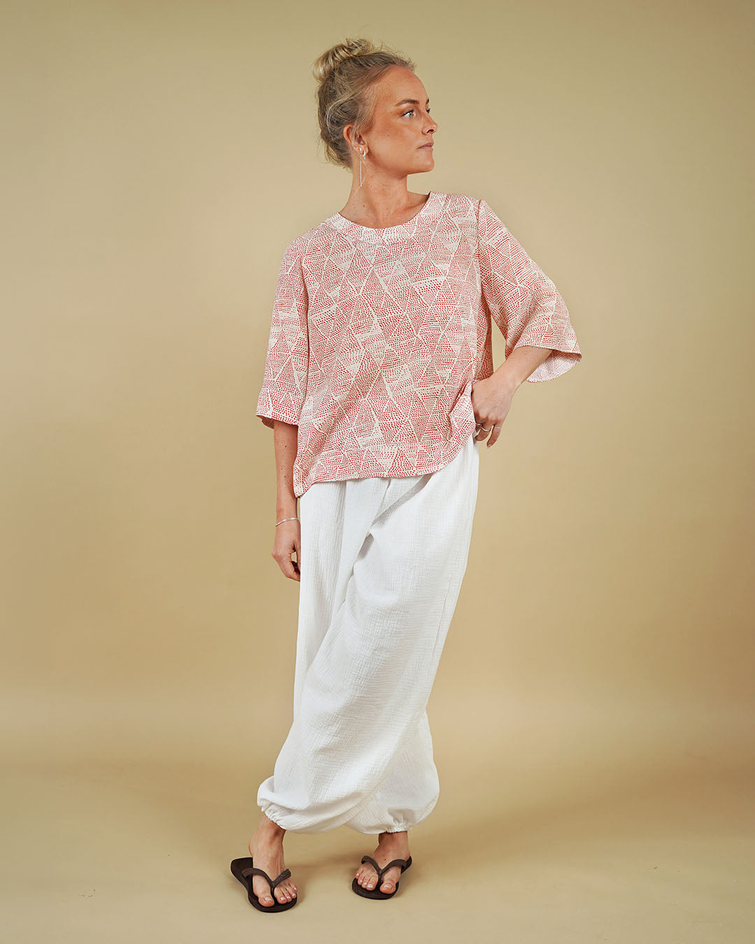 Woman modeling Bubble Pants sewing pattern with a geometric top against a plain background.