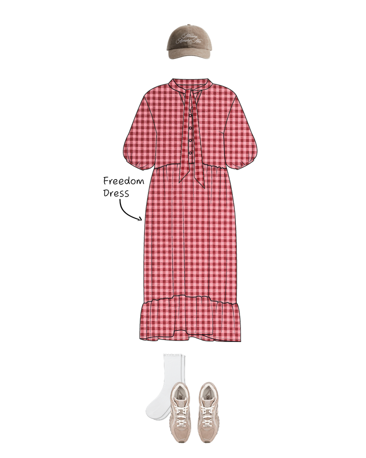Red checkered Freedom dress sewing pattern with beige sneakers, white socks, and a cap on a white background.