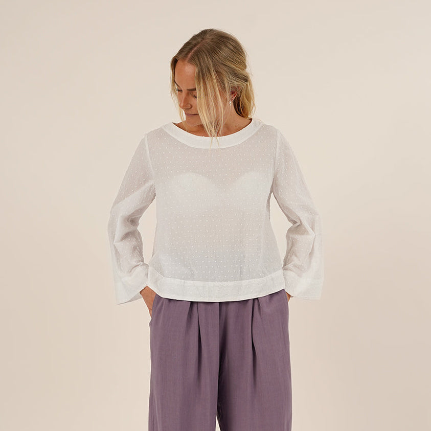 Woman wearing the Silke Blouse sewing pattern in whitecotton and a pair of Palazzo Pants in purple viscose