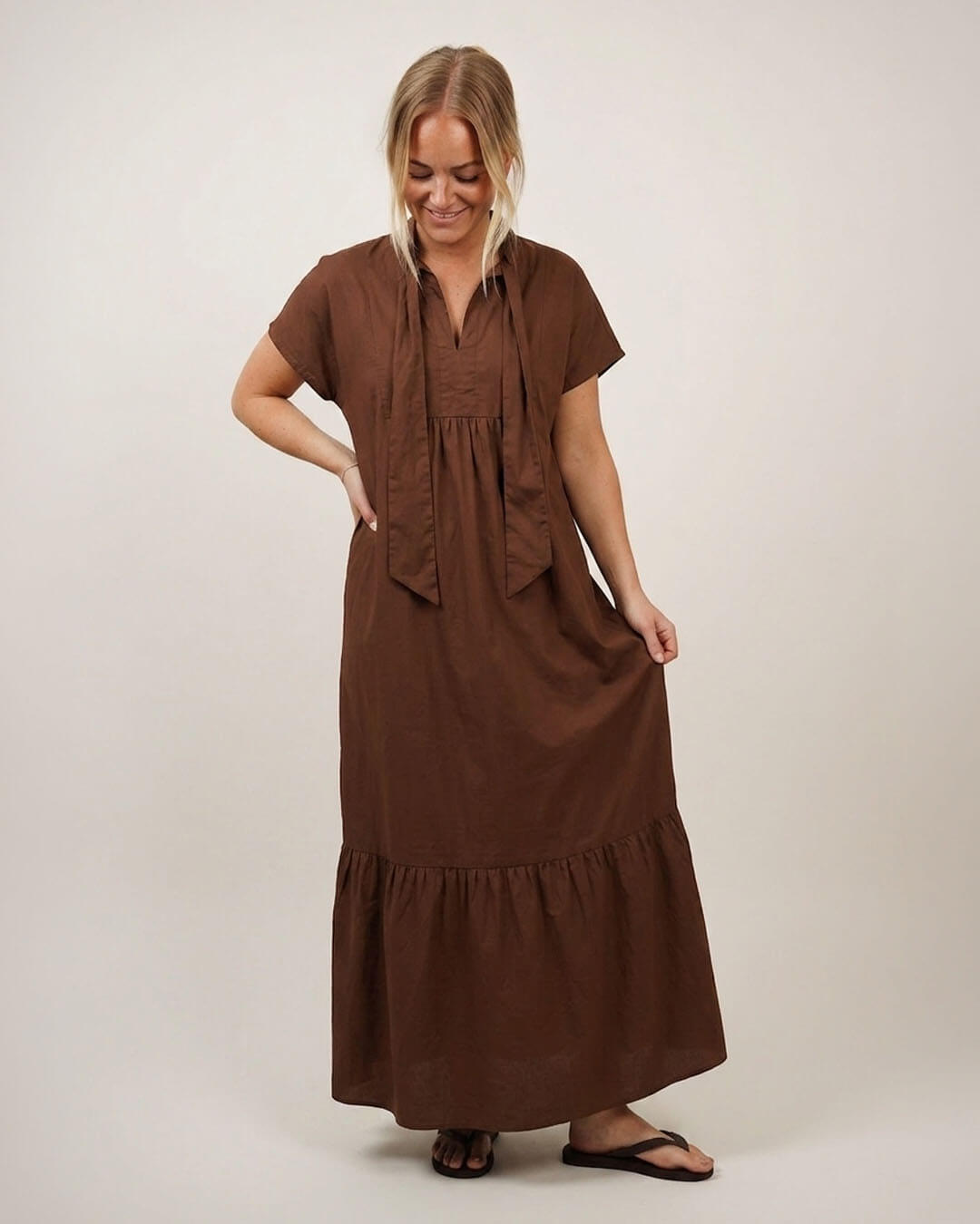 Woman wearing the Aurora dress in brown cotton poplin