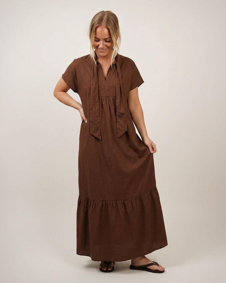 Woman wearing the Aurora dress in brown cotton poplin