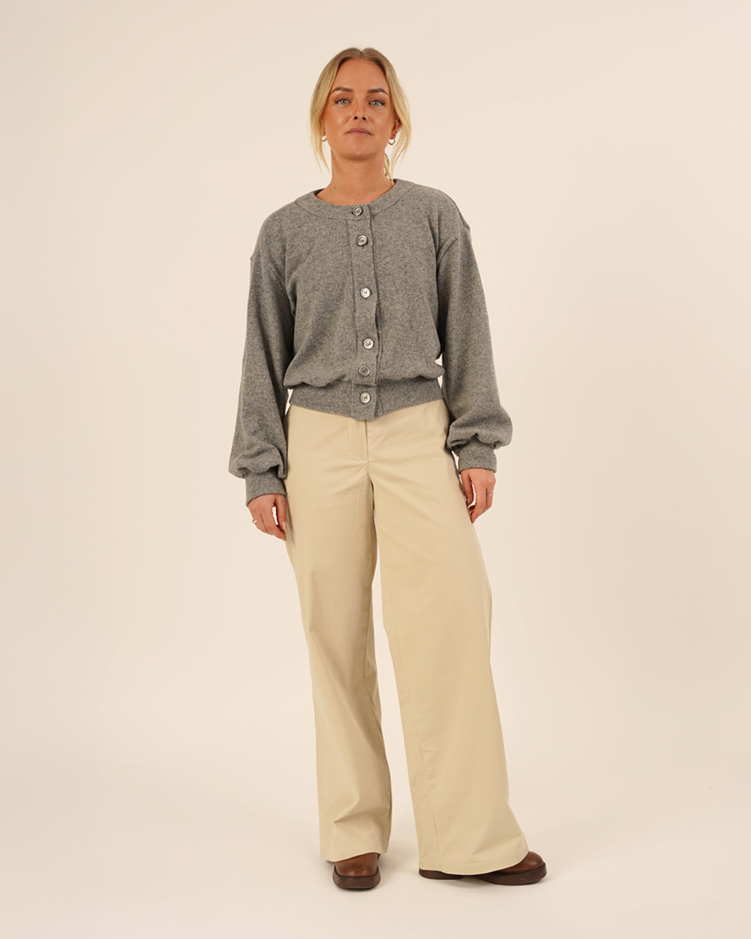 Woman wearing the Balloon Cardigan sewing pattern in grey knit fabric paired with Hepburn Pants in beige cotton twill, front view