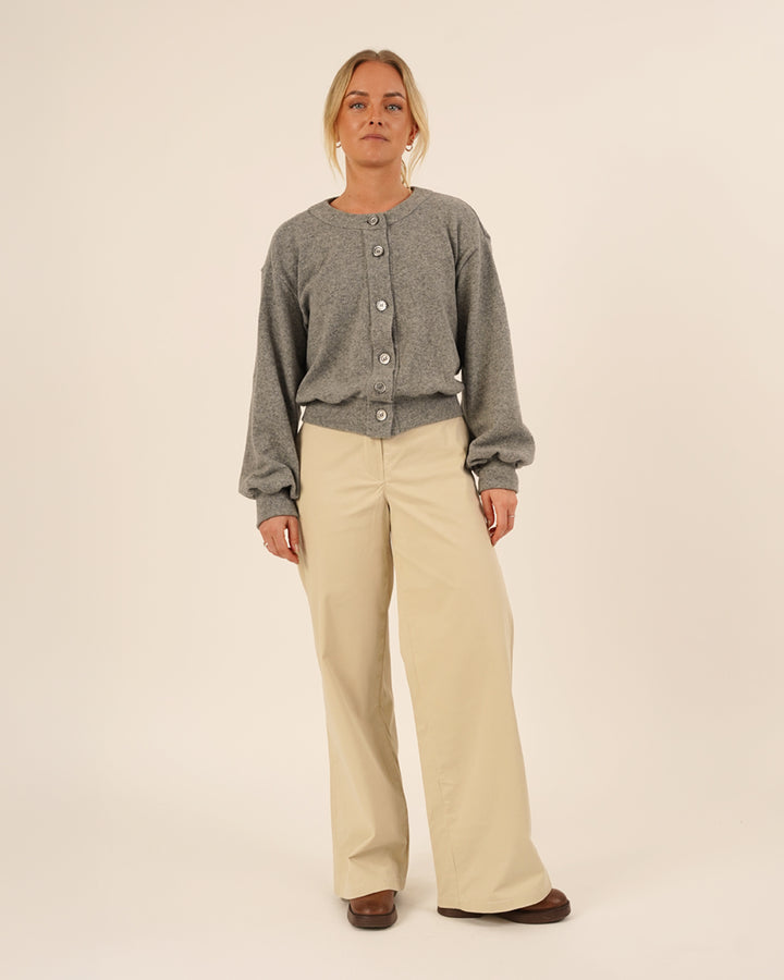 Woman wearing the Balloon Cardigan sewing pattern in grey knit fabric paired with Hepburn Pants in beige cotton twill, front view