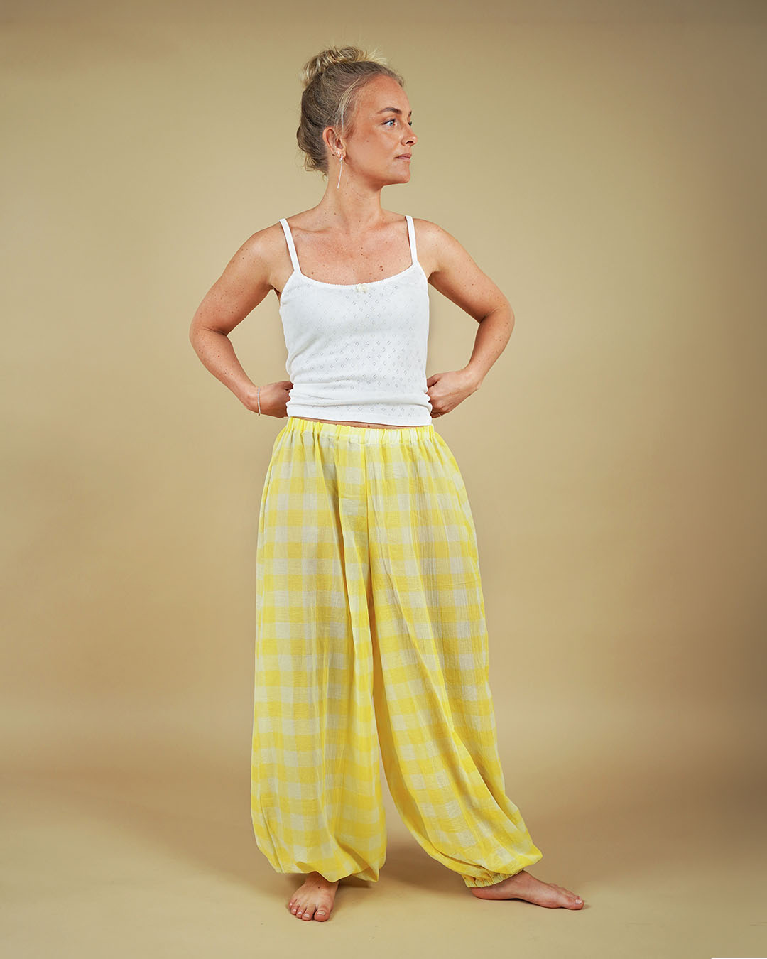 Woman wearing the Carma Camisole and Bubble Pants sewing pattern in yellow checked fabric, front view