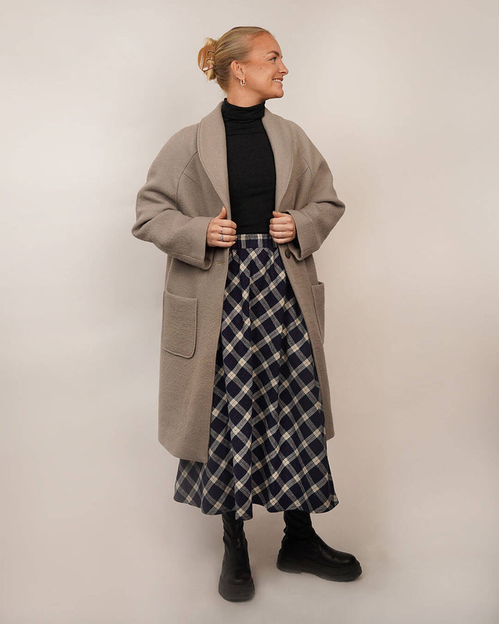 Woman wearing the Cocoon Coat sewing pattern layered over the Claude Skirt sewing pattern, shown from the front