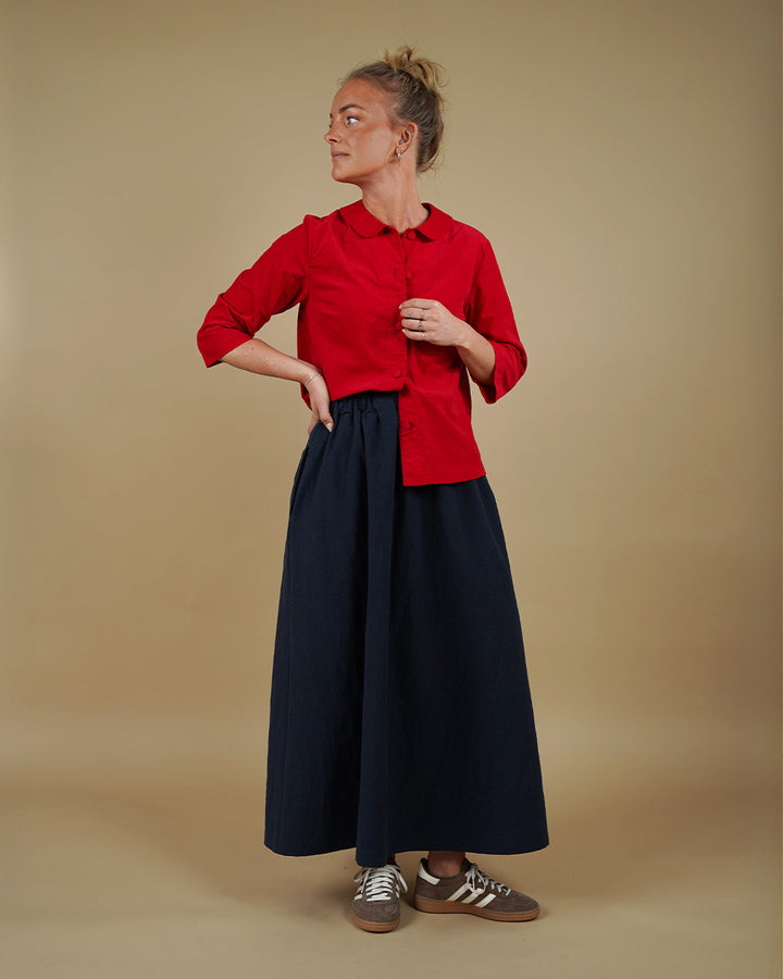 Woman wearing the Dukke Blouse and Claude Skirt sewing pattern, front three-quarter view