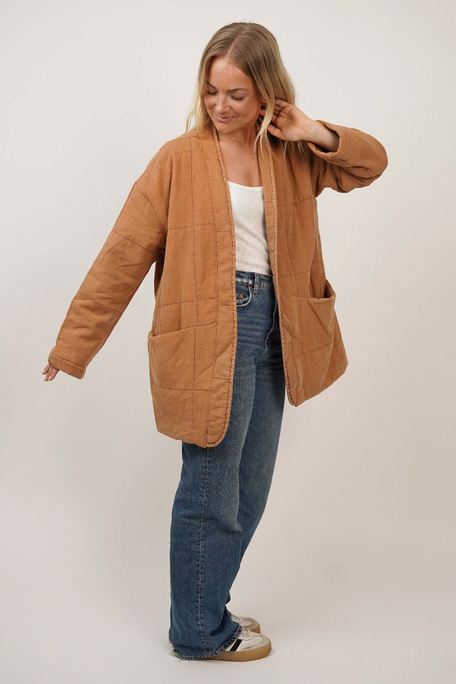 Woman wearing the Komi Wrap Jacket sewing pattern in quilted fabric, front side view