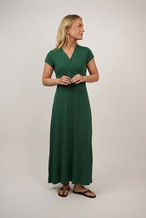 Woman wearing the Mirri Wrap Dress sewing pattern in green jersey, shown from the front with a maxi-length skirt