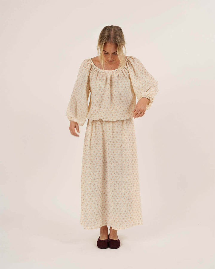 Woman wearing the Moira Blouse and Claude Skirt sewing patterns in cream geometric print fabric, front view