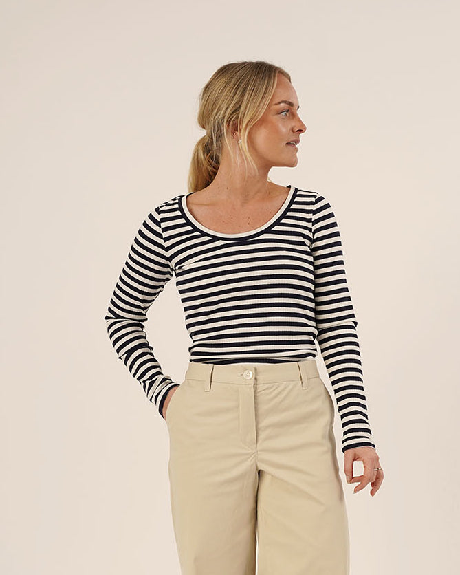Woman wearing the Wardrobe Builder T-shirt sewing pattern in black and white striped knit paired with Hepburn Pants in beige cotton twill, front view