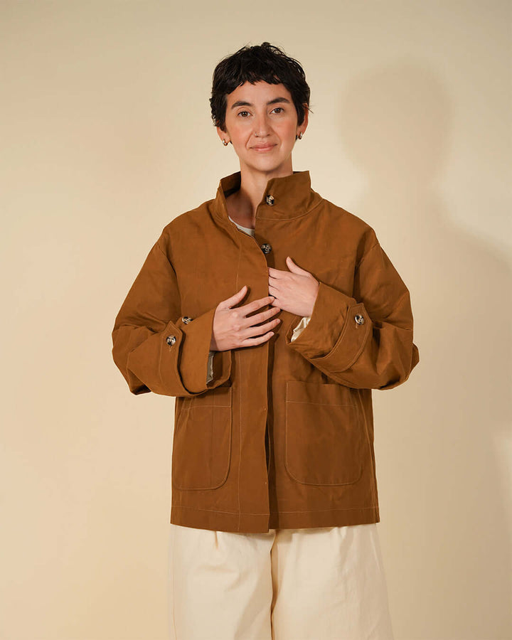 Woman wearing Wardrobe By Me Funnel Neck Jacket sewing pattern in a brown color, showcasing the high collar and relaxed silhouette.