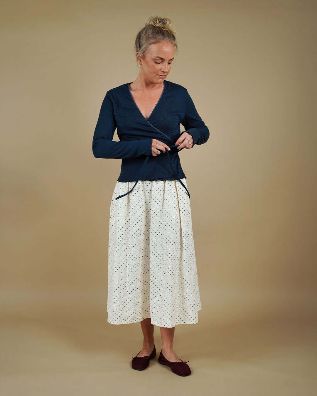 Woman wearing the Wrap Blouse and Claude Skirt sewing pattern, front view