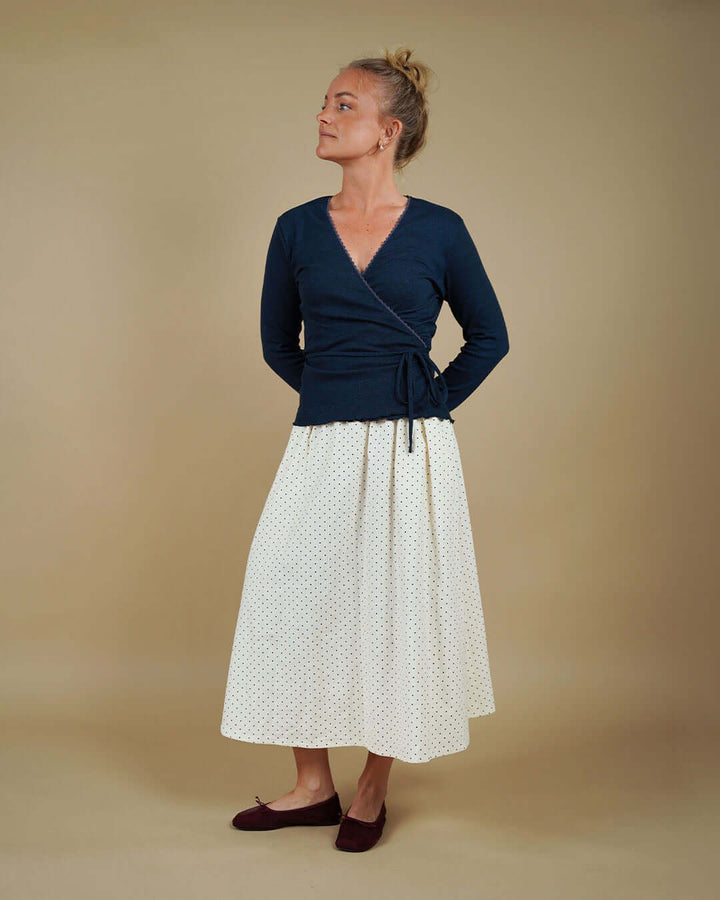 Woman wearing the Wrap Blouse and Claude Skirt sewing pattern, front view