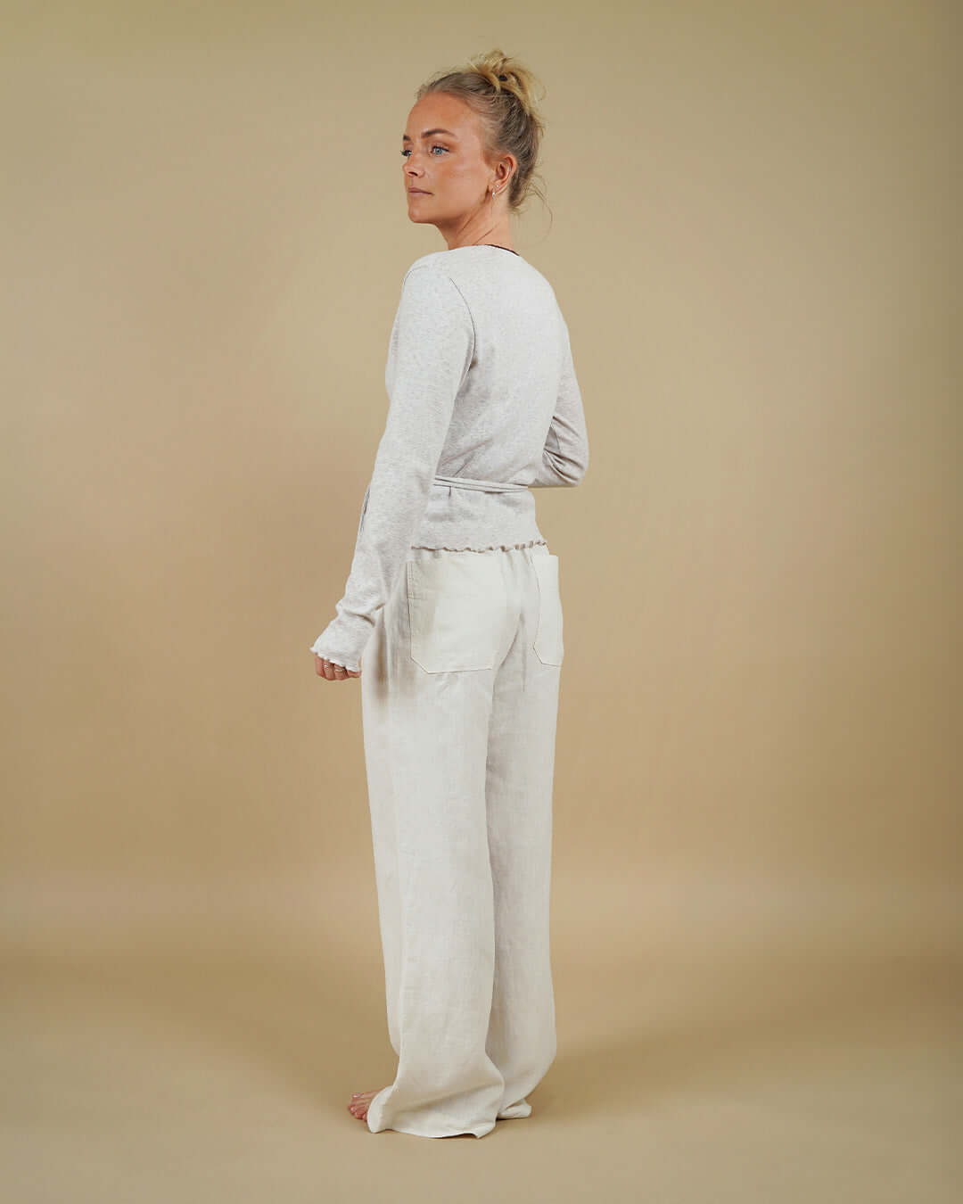 Woman wearing the Wrap Blouse and High Waist Pants sewing pattern, back three-quarter view