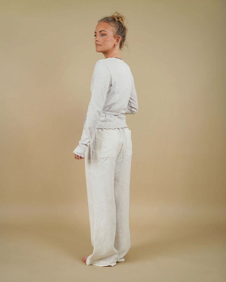 Woman wearing the Wrap Blouse and High Waist Pants sewing pattern, back three-quarter view